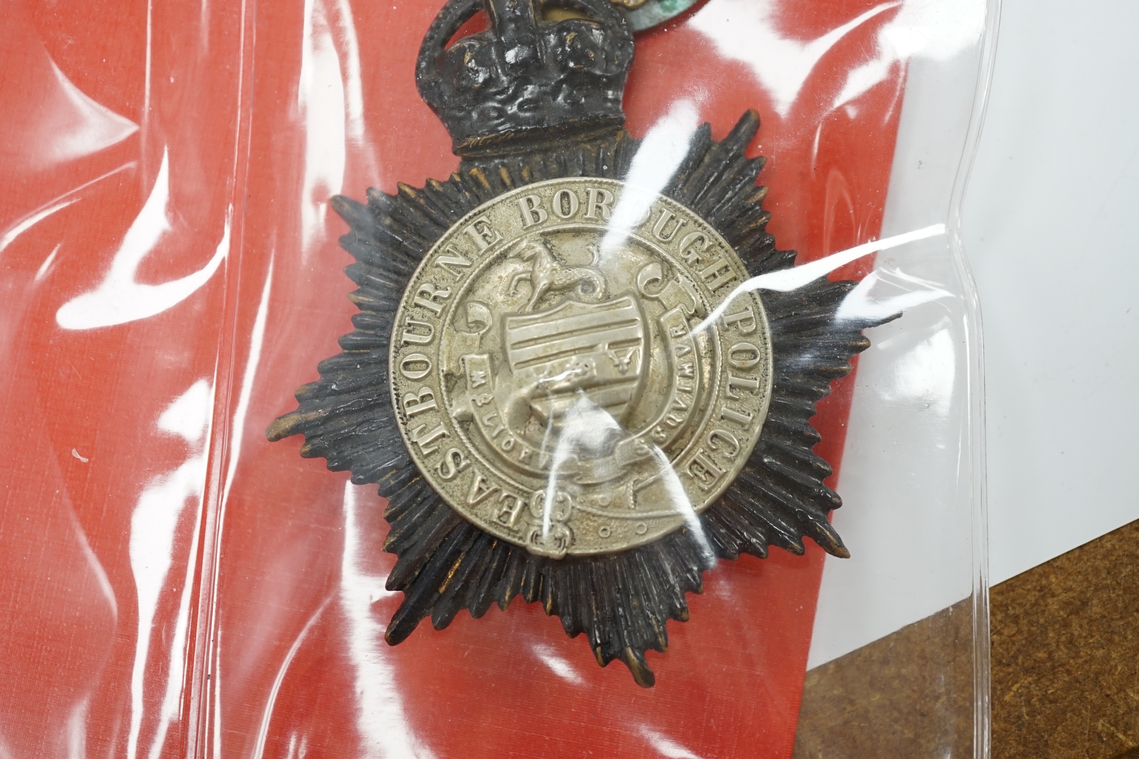 A collection of Police badges and buttons, including to Eastbourne Borough Police helmet plates, Eastbourne Fire Brigade uniform buttons, Royal Navy buttons, a whistle, etc. together with a batten decorated with beadwork